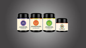 Four glass jars of Elemental Wizdom microbiome & gut health probiotics on a grey background