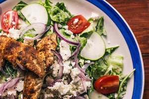 Healthy grilled chicken salad with green leaves, cucumbers & tomatoes
