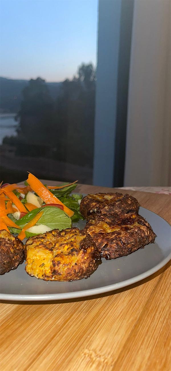 Plate of prawn & sweet potato fritters with healthy salad with sundown view